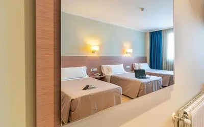 a reflection of a room with two beds in a mirror at Hotel Alba in Puzol