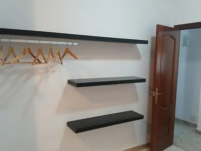 a closet with black shelves and a door at San Juan in Alborache