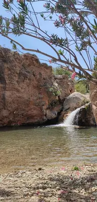 a waterfall in front of a large rock formation at San Juan in Alborache