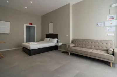 a bedroom with a bed and a couch at VLC Host - Sumsi Studios in Valencia