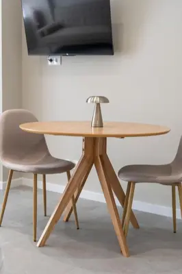 a wooden table with two chairs and a television at VLC Host - Sumsi Studios in Valencia