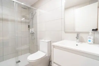 a white bathroom with a toilet and a shower at VLC Host - Sumsi Studios in Valencia