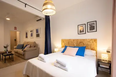a bedroom with a large white bed with blue pillows at LObjet trouvé in Valencia