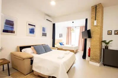 a bedroom with a bed and a couch and a tv at LObjet trouvé in Valencia