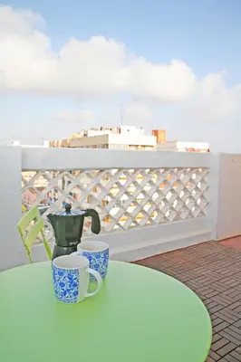 a green table with two cups on a balcony at El Cabanyal - Mar y Atardecer in Valencia