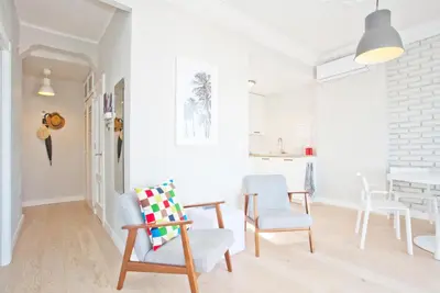 a white living room with chairs and a table at El Cabanyal - Mar y Atardecer in Valencia