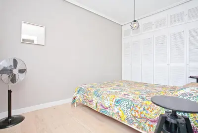 a bedroom with a bed and a table and a fan at El Cabanyal - Mar y Atardecer in Valencia