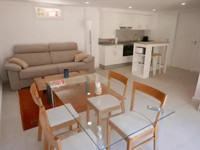 a living room with a table and chairs and a couch at Natural park, terrace and pool in Partida de La Cañada