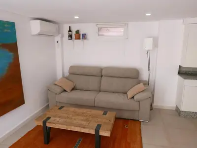 a living room with a couch and a coffee table at Natural park, terrace and pool in Partida de La Cañada