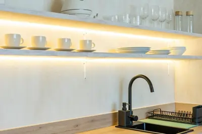 a kitchen with a sink and dishes on a shelf at Nomad HAUX Puerto in Valencia