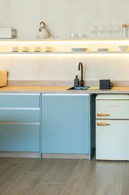 a kitchen with blue and white cabinets and a sink at Nomad HAUX Puerto in Valencia
