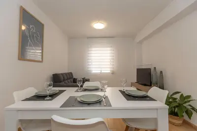 a dining room with a white table and chairs at Bonito Apartamento Paterna 2 Dormitorios in Paterna
