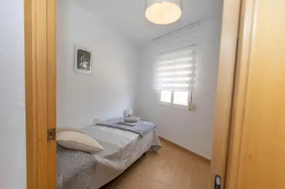 a small bedroom with a bed and a window at Bonito Apartamento Paterna 2 Dormitorios in Paterna
