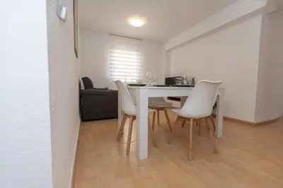 a dining room with a table and white chairs at Bonito Apartamento Paterna 2 Dormitorios in Paterna