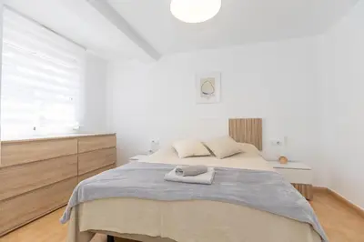 a white bedroom with a bed and a window at Bonito Apartamento Paterna 2 Dormitorios in Paterna