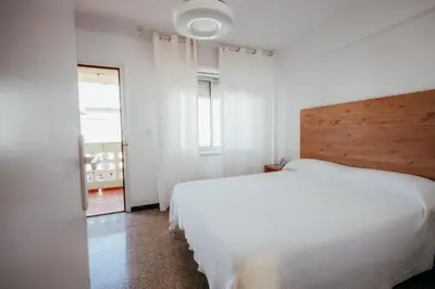 a bedroom with a white bed and a window at Garden at 50m from beach, ChillOut, Large Porche in Mareny Blau
