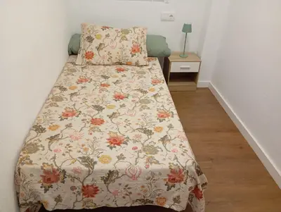 a bedroom with a bed with a floral bedspread at Apartament El Colomer 3 habitacions in Simat de Valldigna