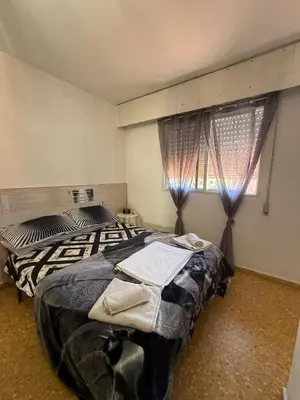 a bedroom with two beds and a window at Habitación confortable in Valencia