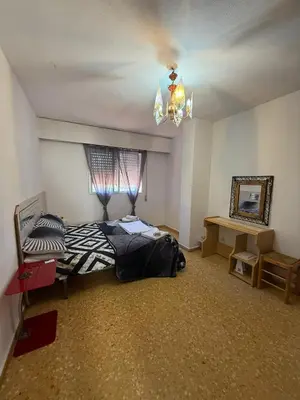 a bedroom with a bed and a chandelier at Habitación confortable in Valencia
