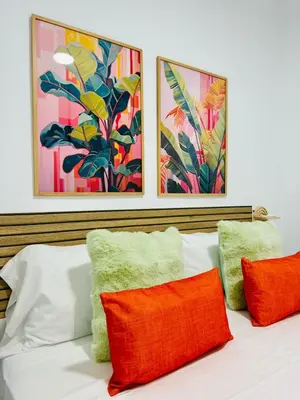 a bed with orange and green pillows on it at Cute & Cozy Aparment Near The Historic Center in Valencia