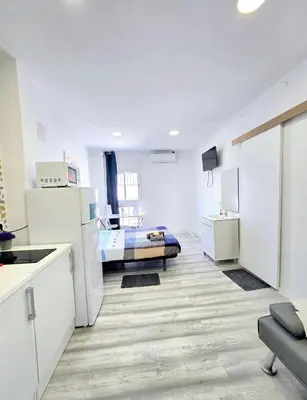 a room with a kitchen and a bed in a room at Apartamentos Lindux Airport in Manises