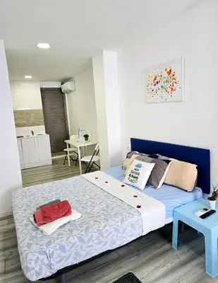 a bedroom with a bed with a blue head board at Apartamentos Lindux Airport in Manises