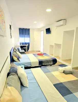 a room with three beds in a room at Apartamentos Lindux Airport in Manises