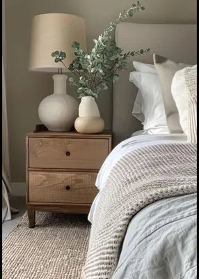 a bed with a table with two vases on it at Mínimal chic apartament in Puerto de Sagunto