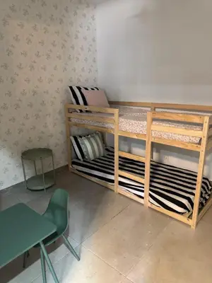 a room with two bunk beds and a chair at Mínimal chic apartament in Puerto de Sagunto