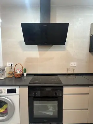 a kitchen with a dishwasher and a tv on the wall at Mínimal chic apartament in Puerto de Sagunto