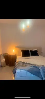 a bedroom with two beds and a light on the wall at Mínimal chic apartament in Puerto de Sagunto