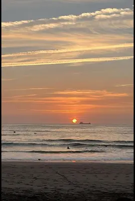 a sunset on the beach with the sun setting at Mínimal chic apartament in Puerto de Sagunto