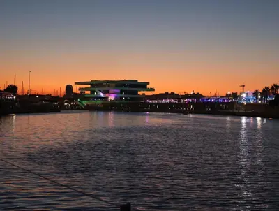 a large body of water with a building in the background at Magnificent sailboat with free parking for cars in Valencia