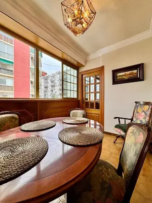 a dining room with a wooden table and chairs at Wagner Playa Apartment in Cullera