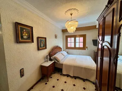 a bedroom with a bed and a chandelier at Wagner Playa Apartment in Cullera