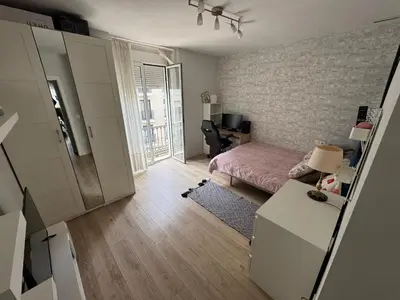a bedroom with a bed and a desk with a chair at Habitación en el centro con balcón in Valencia