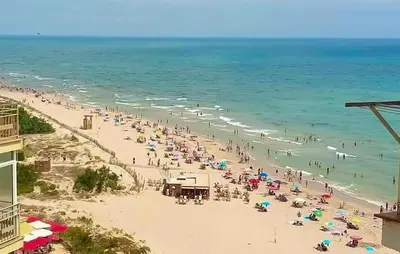 a group of people on a beach with the ocean at Lovely Apartment In Faro De Cullera in Faro de Cullera