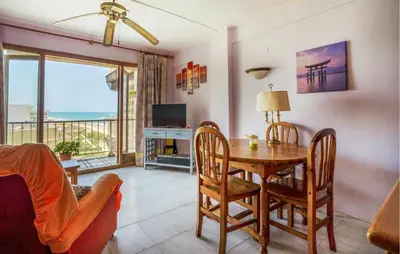 a living room with a table and chairs and a television at Lovely Apartment In Faro De Cullera in Faro de Cullera