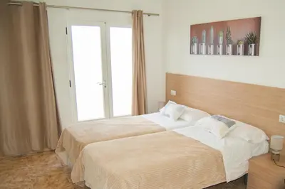 a bedroom with a large bed and a large window at Complejo Turistico la Pinada in Gilet