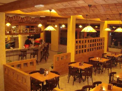 a restaurant with wooden tables and chairs and a bar at Complejo Turistico la Pinada in Gilet