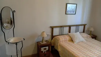 a bedroom with a bed and a table with a mirror at Les Eres de Gátova in Gátova