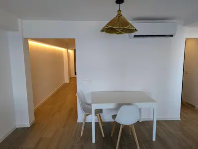 a dining room table with chairs and a pendant light at Apartamento en Primera Línea in Cullera