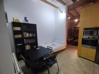 a living room with a table and a couch and a kitchen at Cozy apartment in the old town - San Ramon in Valencia