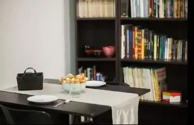 a table with plates and a bowl of fruit in a book shelf at Cozy apartment in the old town - San Ramon in Valencia