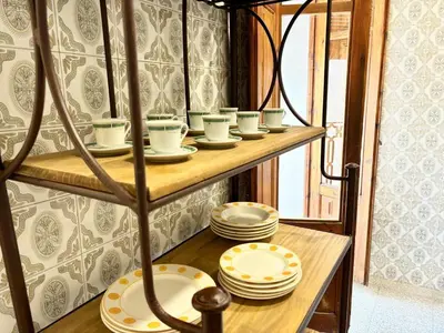 a shelf with plates and cups and dishes on it at Your stylish retreat in Sierra Espadán in Vall de Almonacid