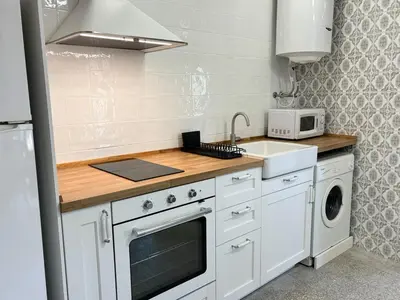 a small kitchen with a stove and a sink at Your stylish retreat in Sierra Espadán in Vall de Almonacid