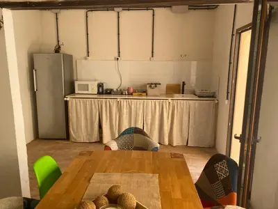 a kitchen with a table and a counter with a refrigerator at La Terreta hotel casa rural in El Brosquil