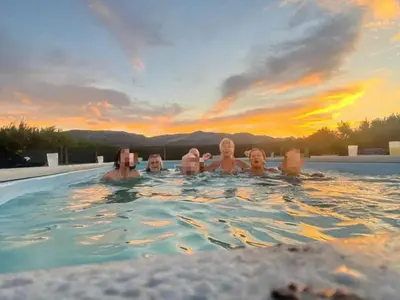 a group of people in a swimming pool at sunset at La Terreta hotel casa rural in El Brosquil