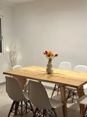 a wooden table with a vase of flowers on it at Abadesa Apartments in Benetúser