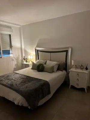 a white bedroom with a large bed with pillows at Abadesa Apartments in Benetúser
